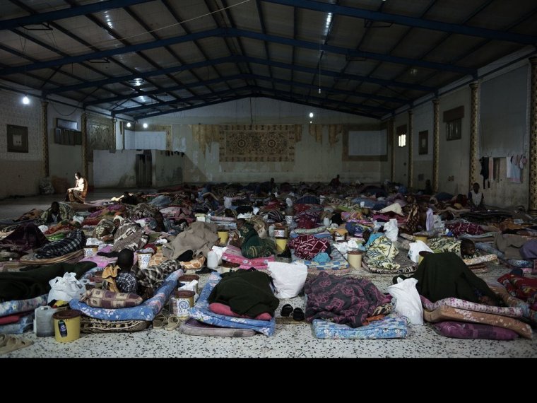 Des migrants sont couchés sur des matelas à l'intérieur d'un centre de détention, situé en Libye. (archive)